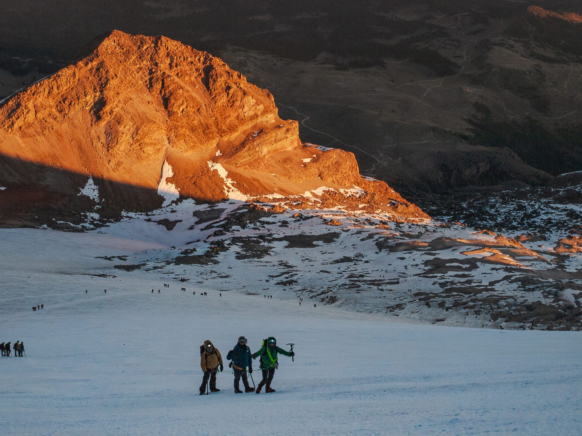 Climbers ascending glacier at golden sunrise — Mexico volcano expedition