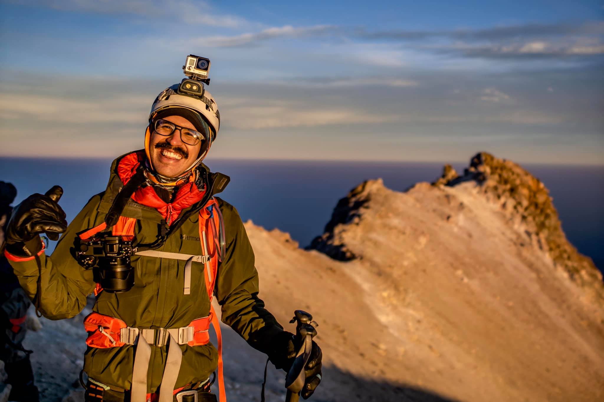 Climber on the Iztaccíhuatl summit with Popocatépetl in the background