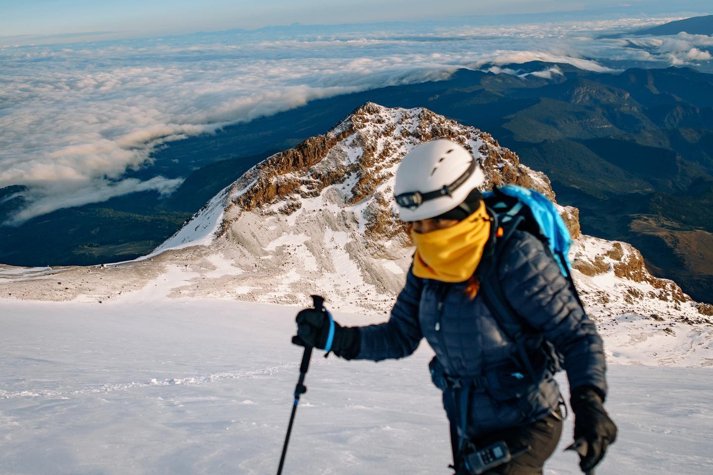Climber on Pico de Orizaba glacier with mountain range in the background
